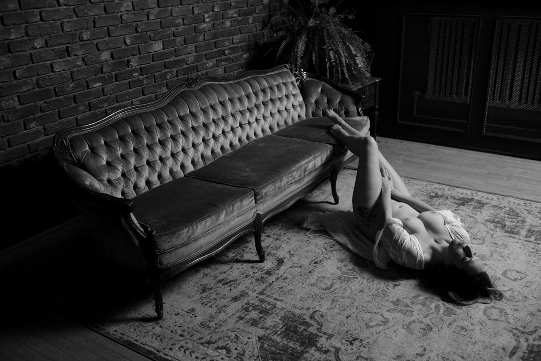 full body boudoir image of topless woman lying on floor in a robe